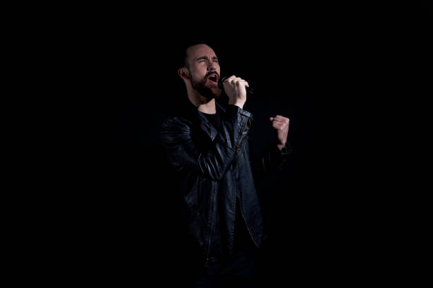 istock Handsome man singing with microphone and wearing leather jacket 1171182104