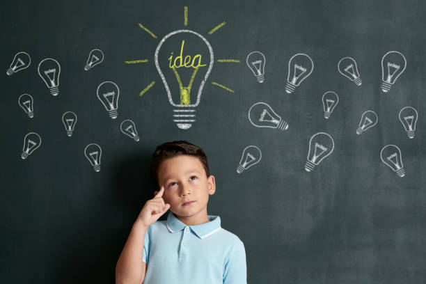 istock 6-7 years child is finding idea on front of blackboard 1171182214