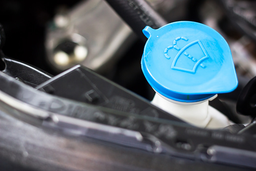 Blue Windshield wiper cap inside a car engine, reserving a water for cleaning screen, Car Mechanic Background