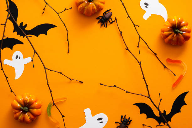 istock Happy halloween holiday concept. Halloween decorations, pumpkins, bats, candy, ghosts, bugs on orange background. Halloween party greeting card. Flat lay, top view, overhead. 1171184631