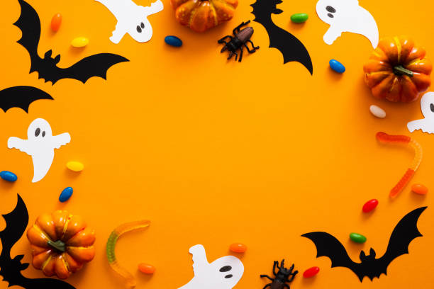 istock Happy halloween holiday concept. Halloween decorations, pumpkins, bats, candy, ghosts, bugs on orange background. Halloween party greeting card mockup with copy space. Flat lay, top view, overhead. 1171184659
