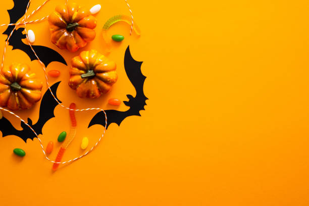 istock Happy halloween holiday concept. Halloween decorations, pumpkins, bats, candy, ghosts, bugs on orange background. Halloween party greeting card mockup with copy space. Flat lay, top view, overhead. 1171184674