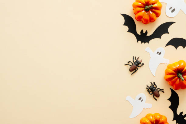 istock Halloween composition. Halloween decorations, pumpkins, ghosts, paper bats, spiders on pastel beige background. Halloween concept. Flat lay, top view, copy space 1171184730