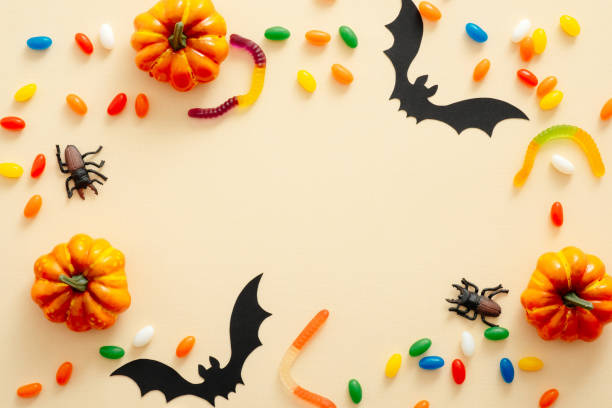 istock Halloween composition. Halloween decorations, pumpkins, candy, paper bats on pastel beige background. Halloween concept. Flat lay, top view, copy space 1171184739