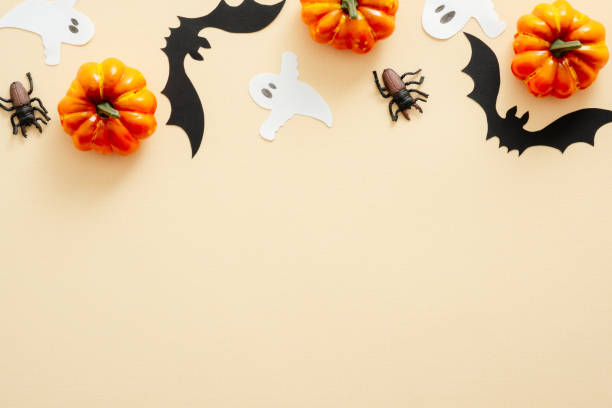 istock Halloween composition. Halloween decorations, pumpkins, paper ghost, spiders on pastel beige background. Halloween concept. Flat lay, top view, copy space 1171184926