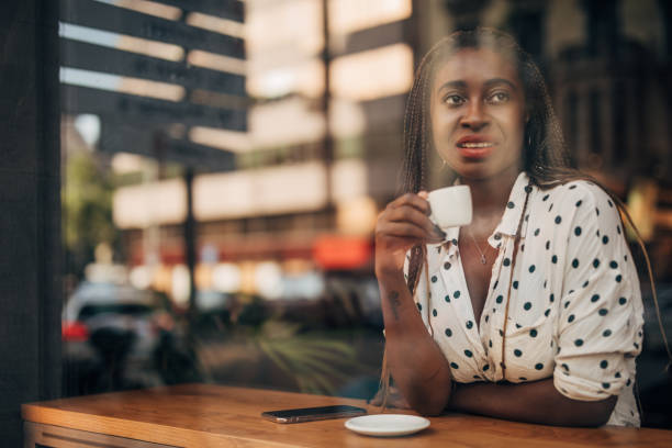 istock Young woman drinking coffee at the cafe 1171186073