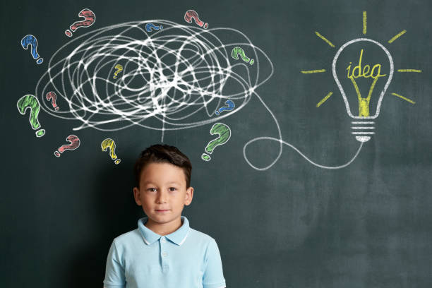 istock 6-7 years child is finding solution on front of blackboard 1171188944