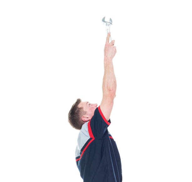 istock Young handsome male mechanic standing on white background - pointing up 1171190130