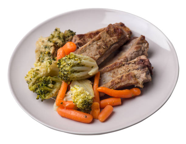 istock grilled pork ribs with broccoli cabbage, carrots and garlic on a plate. fried   ribs with vegetables on a white background. hearty rustic food top view 1171191998