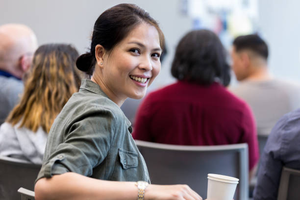 istock Waiting for lecture to start, female veteran smiles for camera 1171197403