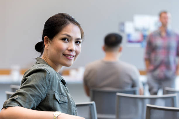 During seminar, female veteran turns and smiles for camera