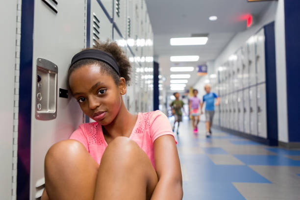 istock Sad girl in school hallway 1171197473