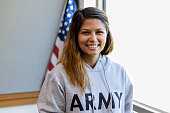 Female veteran with big smile in front of American flag