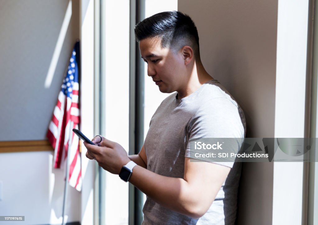 Mid adult veteran takes time from meeting to text wife The mid adult military veteran takes time from the meeting to text his wife on his smart phone. Military Stock Photo