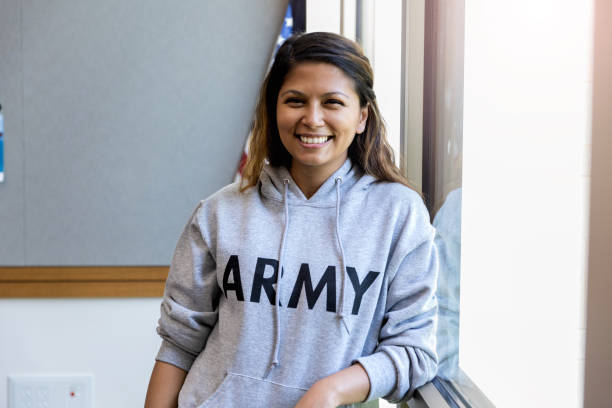 female army vet leans against window and smiles for camera - therapy people cheerful looking at camera imagens e fotografias de stock