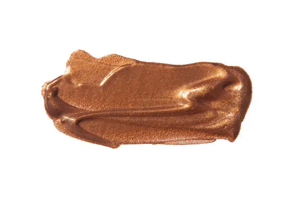 Bronze colored metallic paint make-up, brush stroke, isolated on white close up with copy space, no people