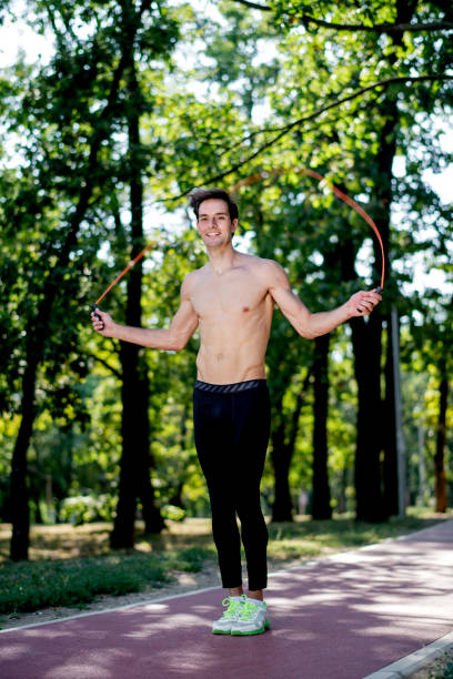 istock Young man exercising jumping rope in nature 1171203877