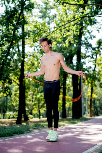 istock Young man exercising jumping rope in nature 1171204673