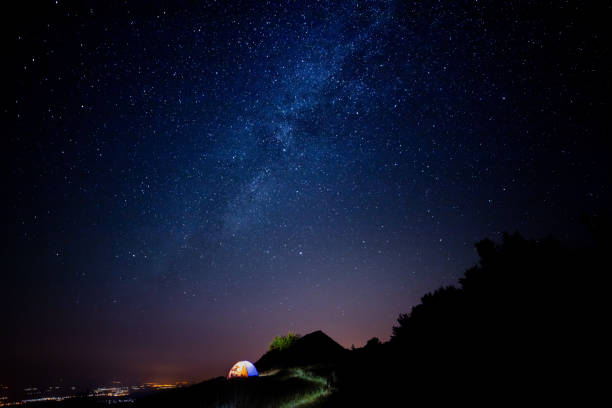istock Camping at night in the mountains under starry sky 1171206671