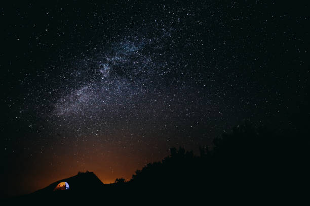 istock Camping at night in the mountains under starry sky 1171207223
