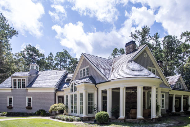 istock Rear view and backyard of large cape cod style home with columns and windows and a round porch patio 1171207481