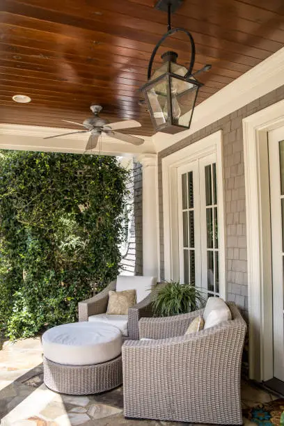 Photo of outdoor patio porch of traditional upgraded custom home with seating for entertaining and dining in cream and tan colors