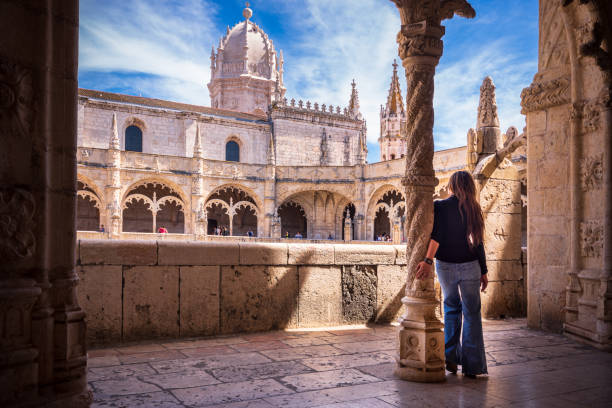 Woman visiting cloisters of Jeronimos Monastery in Lisbon, Portugal stock photo
