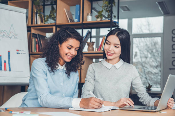 istock Female startupers working together at office sitting browsing laptop taking notes cheerful 1171217800