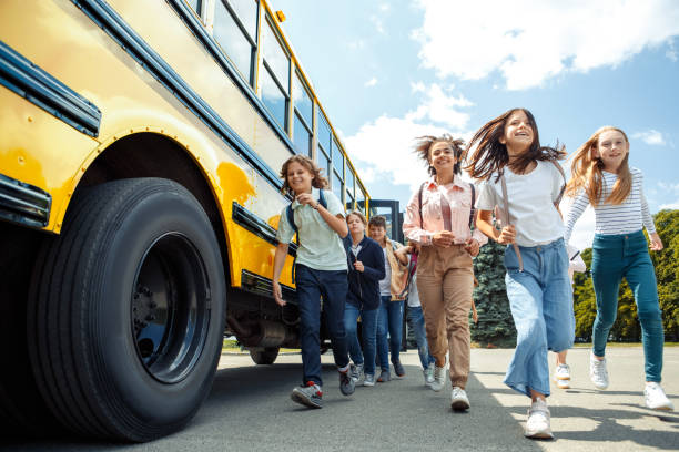 istock Classmates running from school bus back home looking forward smilign excited 1171218133