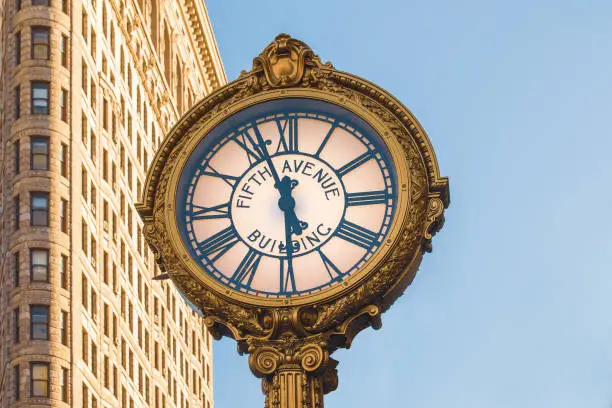 5TH Avenue clock with the Flatiron Building in the background