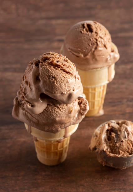 istock Chocolate Ice Cream Cone on a Rustic Wooden Table 1171222355