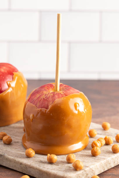 istock Beautiful Caramel Apples on a Rustic Kitchen Cabinet Ready for Fall 1171222466