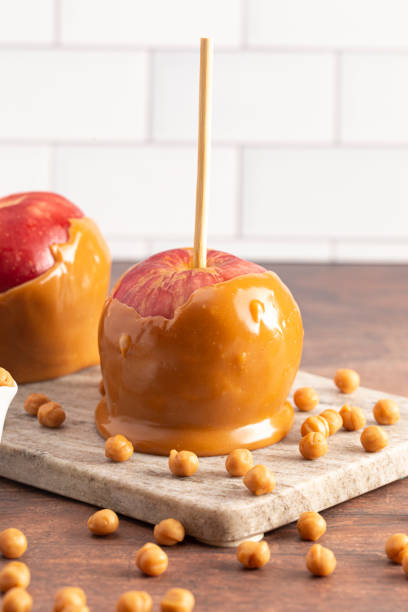 istock Beautiful Caramel Apples on a Rustic Kitchen Cabinet Ready for Fall 1171223051