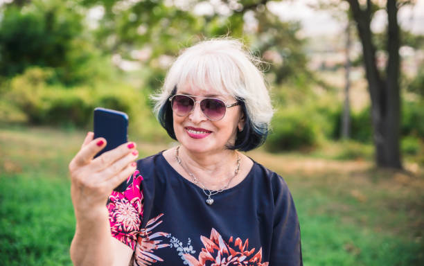 istock Smiling Senior Woman using mobile phone 1171230382
