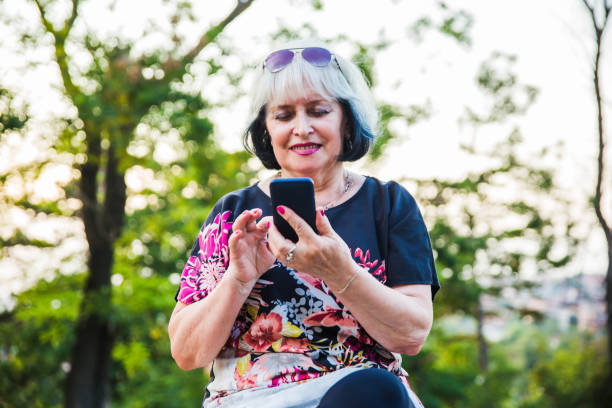 istock Senior Woman using mobile phone outdoor. 1171230387