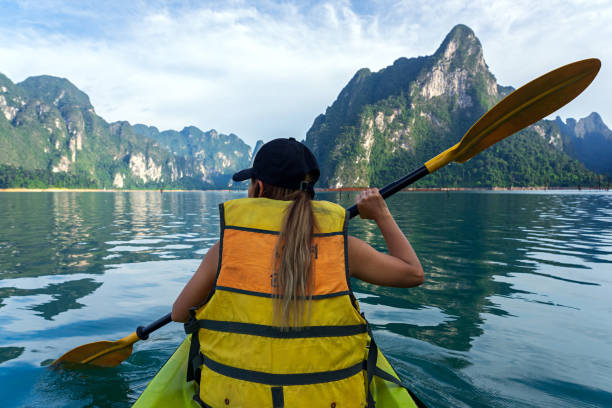 азиатка в желтом спасательный жилет каякинг в озере - women kayaking life jacket kayak стоковые фото и изображения