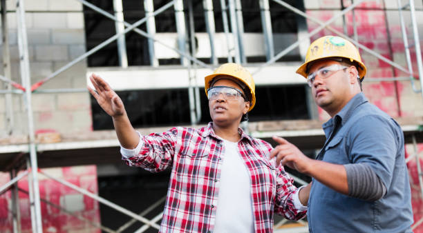 dois trabalhadores que falam em um canteiro de obras, apontando - business meeting business person worried latin american and hispanic ethnicity - fotografias e filmes do acervo