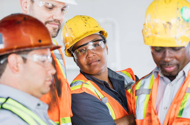 istock Female construction worker with group of coworkers 1171238994