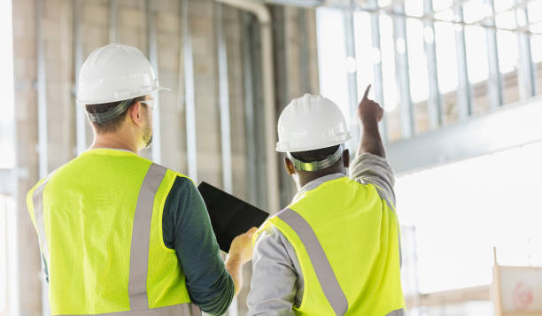 dwóch pracowników budowlanych z cyfrowym tabletem - foreman building contractor hardhat men zdjęcia i obrazy z banku zdjęć