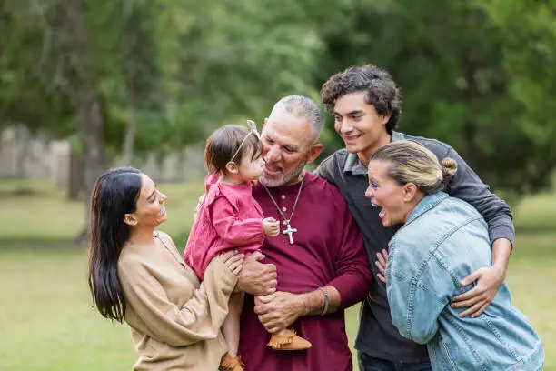 Photo of Multi-generation Hispanic family, getting baby to smile