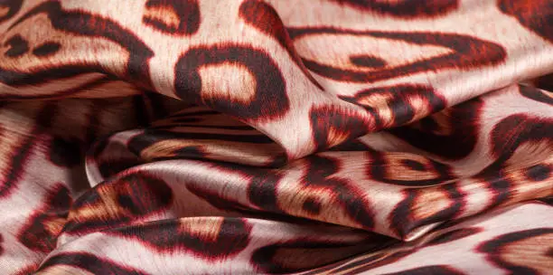 Photo of texture, background, pattern. silk fabric, tiger skin, light and silky soft, this atlas charmeuse is perfect for your projects - especially on bias. Colors include tan, black and brown.