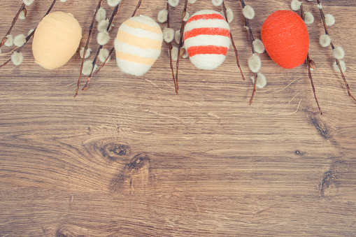 Foto vintage, amentos de Pascua y huevos envueltos cadena de lana en tablero rústico, decoración festiva, espacio de copia para texto photo