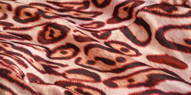 Photo of texture, background, pattern. silk fabric, tiger skin, light and silky soft, this atlas charmeuse is perfect for your projects - especially on bias. Colors include tan, black and brown.
