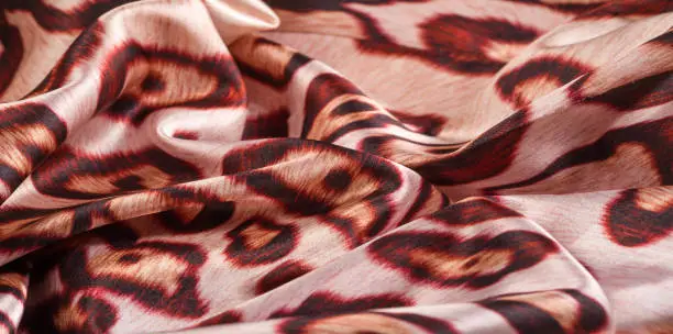 Photo of texture, background, pattern. silk fabric, tiger skin, light and silky soft, this atlas charmeuse is perfect for your projects - especially on bias. Colors include tan, black and brown.