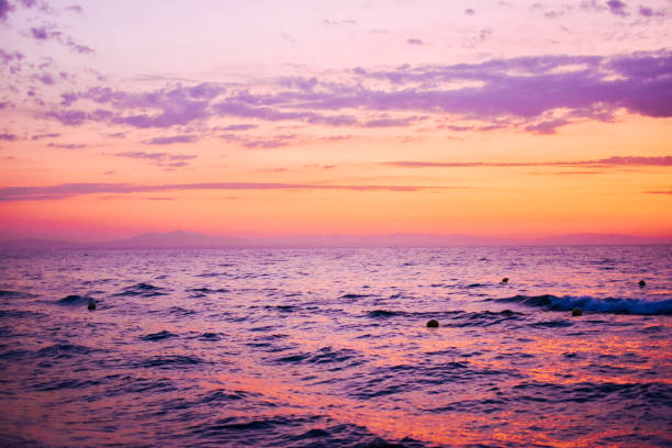 Bright sunset with large yellow sun under the sea surface, high waves near the sea or ocean, fot or concept