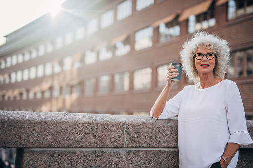 Senior woman in the city drinking coffee