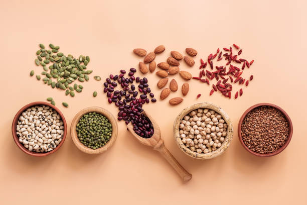 Healthy vegan and vegetarian super foods, beans, pumpkin seeds, chickpeas, buckwheat, mung beans, almonds and goji berries on a pastel pink background. Top view, flat lay, copy space. Healthy vegan and vegetarian super foods, beans, pumpkin seeds, chickpeas, buckwheat, mung beans, almonds and goji berries on a pastel pink background. Top view, flat lay, copy space red mung bean stock pictures, royalty-free photos & images