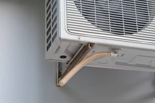 Photo of Street air conditioner and drain pipe close-up.