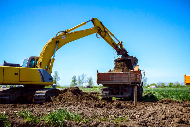 istock Excavator is loading a truck with ground on building site 1171263812