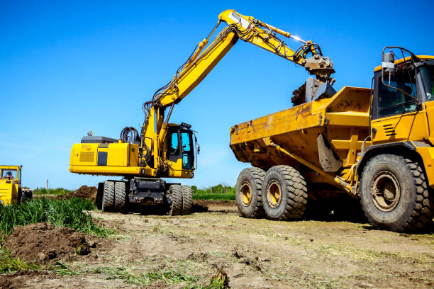 istock Excavator is loading a truck with ground on building site 1171265113